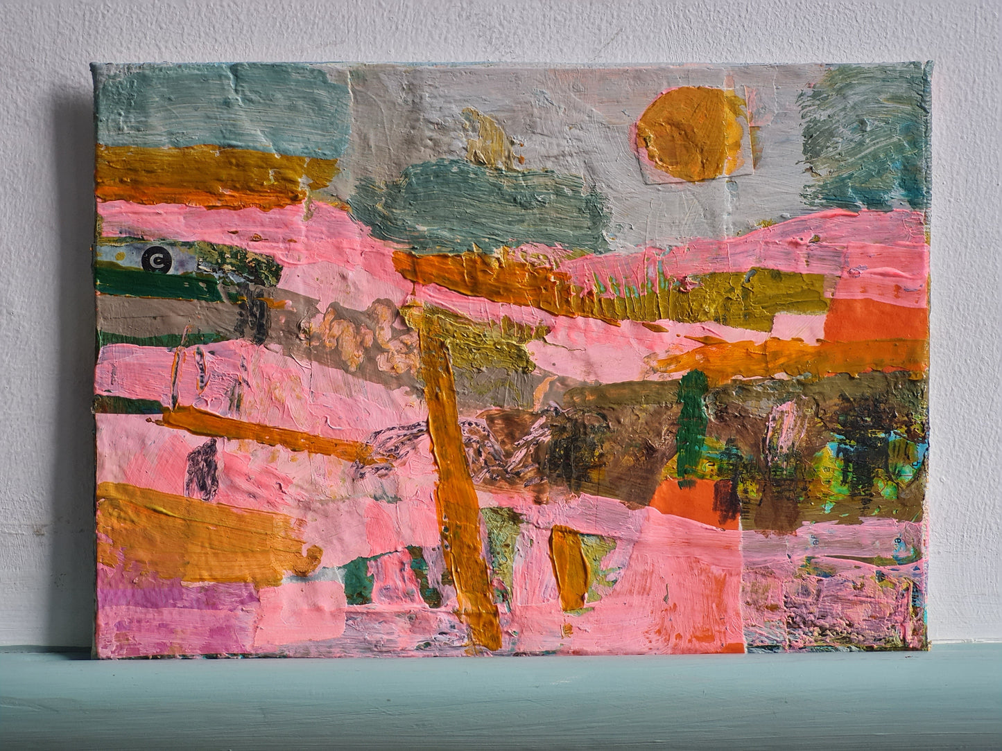 Abstract painting with pink, orange, and green colours on a light grey background