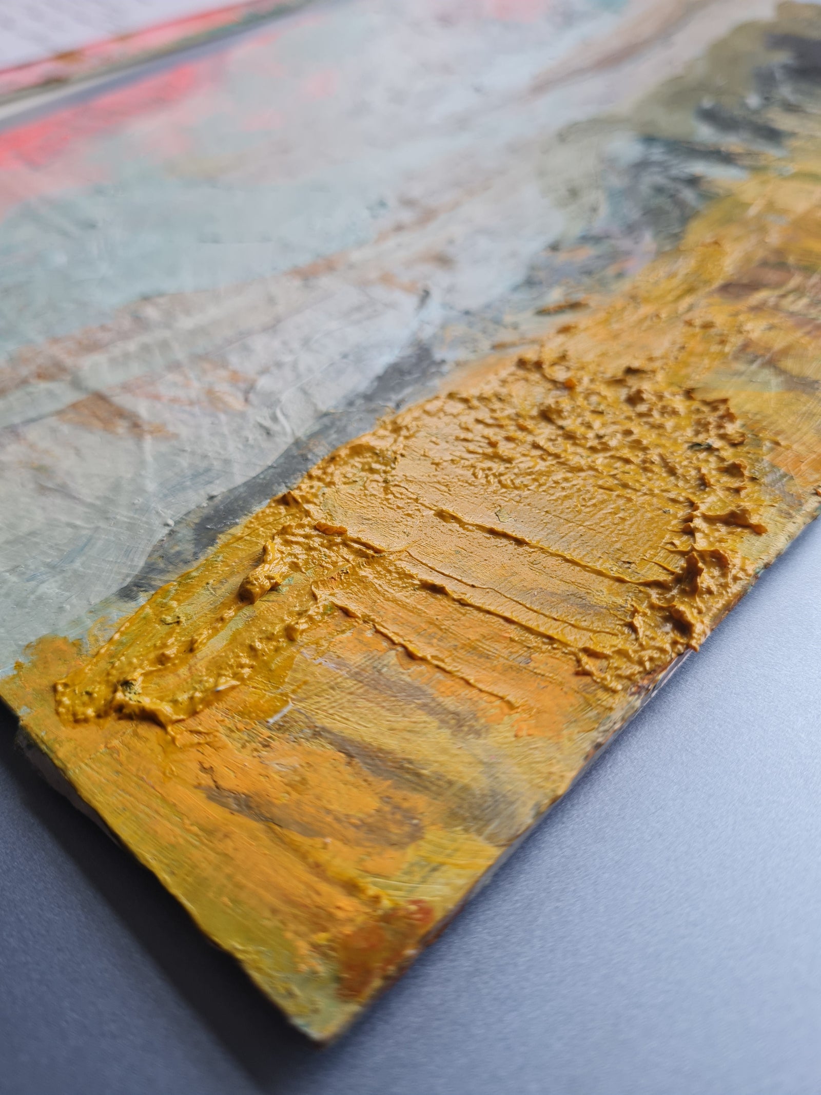 Close-up of a textured paint surface with gold and grey colours