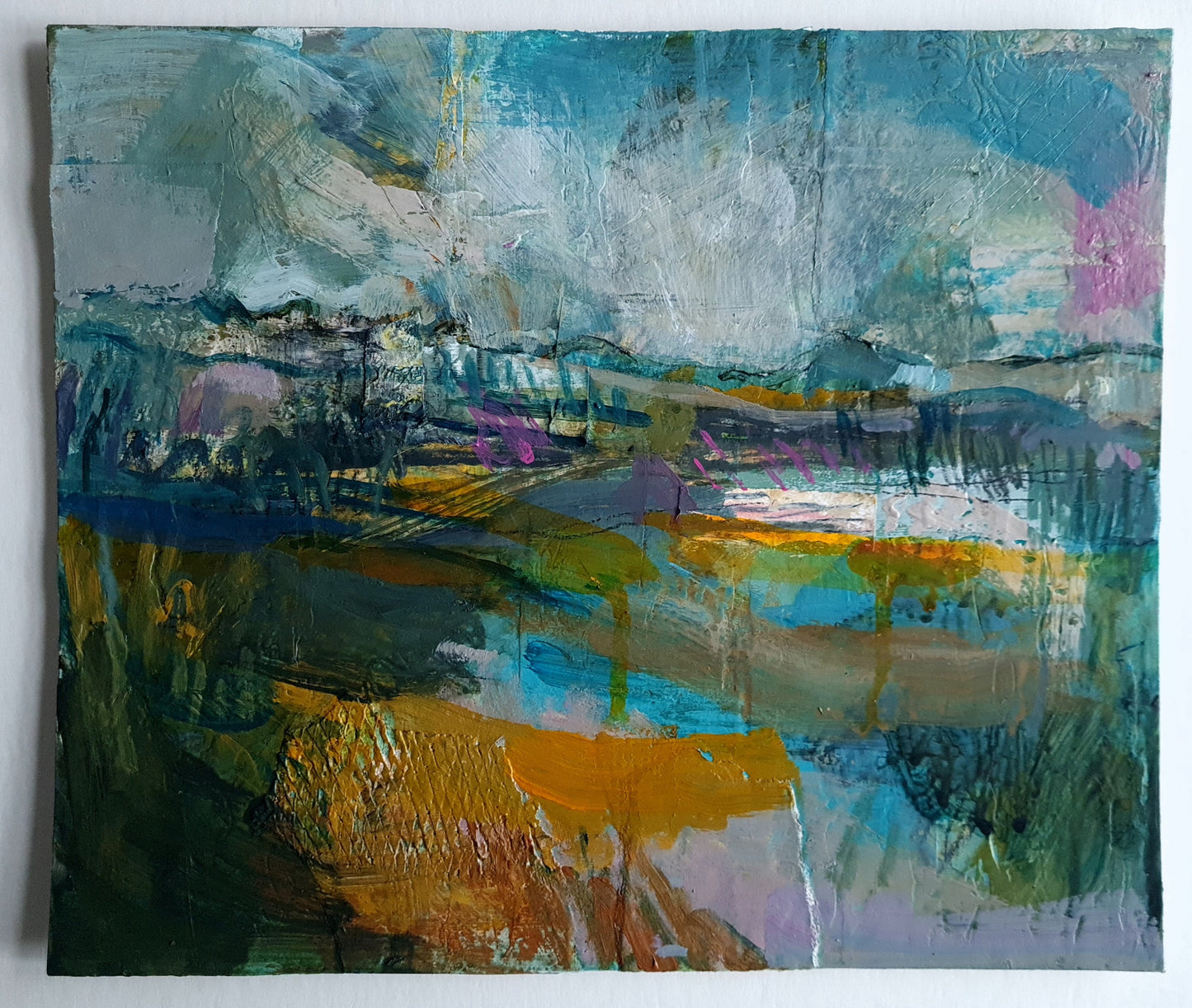 Abstract painting created in blue, mustard and muted grey paint colours, on a white background