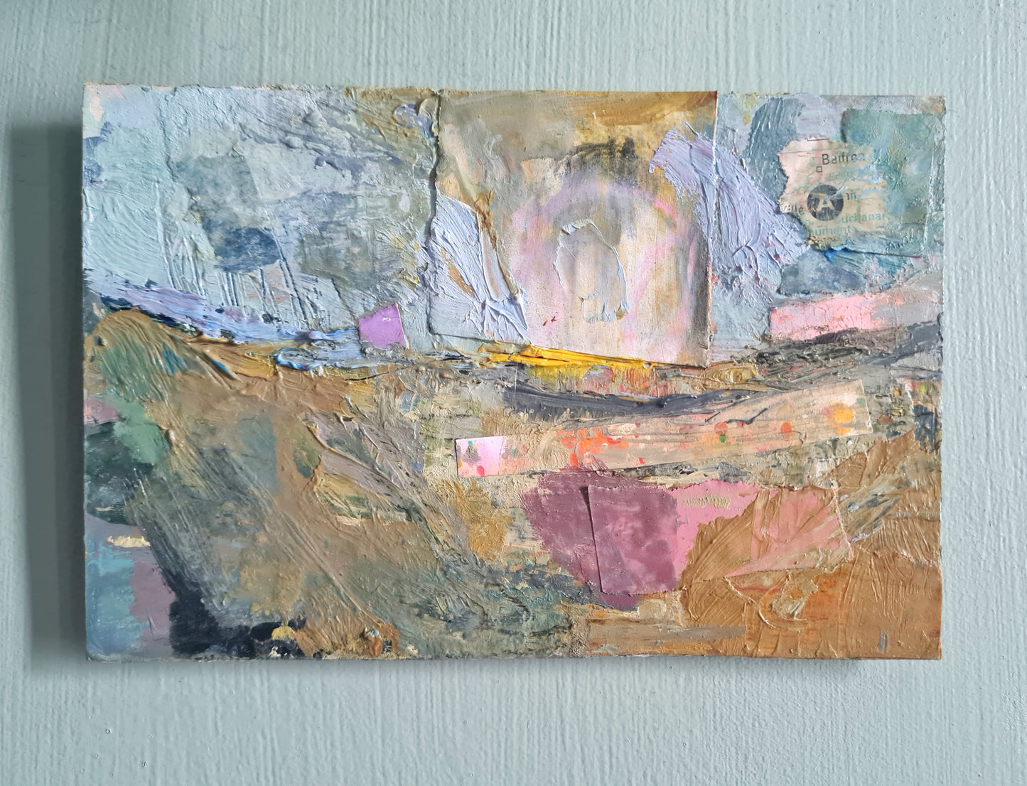 Abstract painting on a light sage green wall