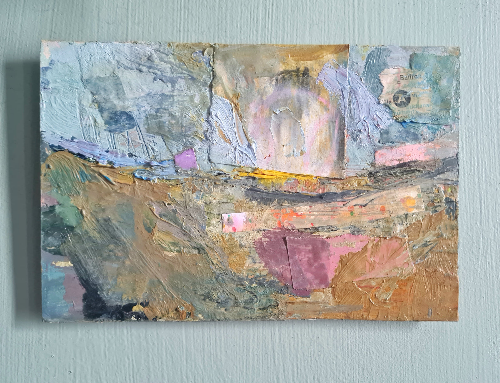 Abstract painting on a light sage green wall