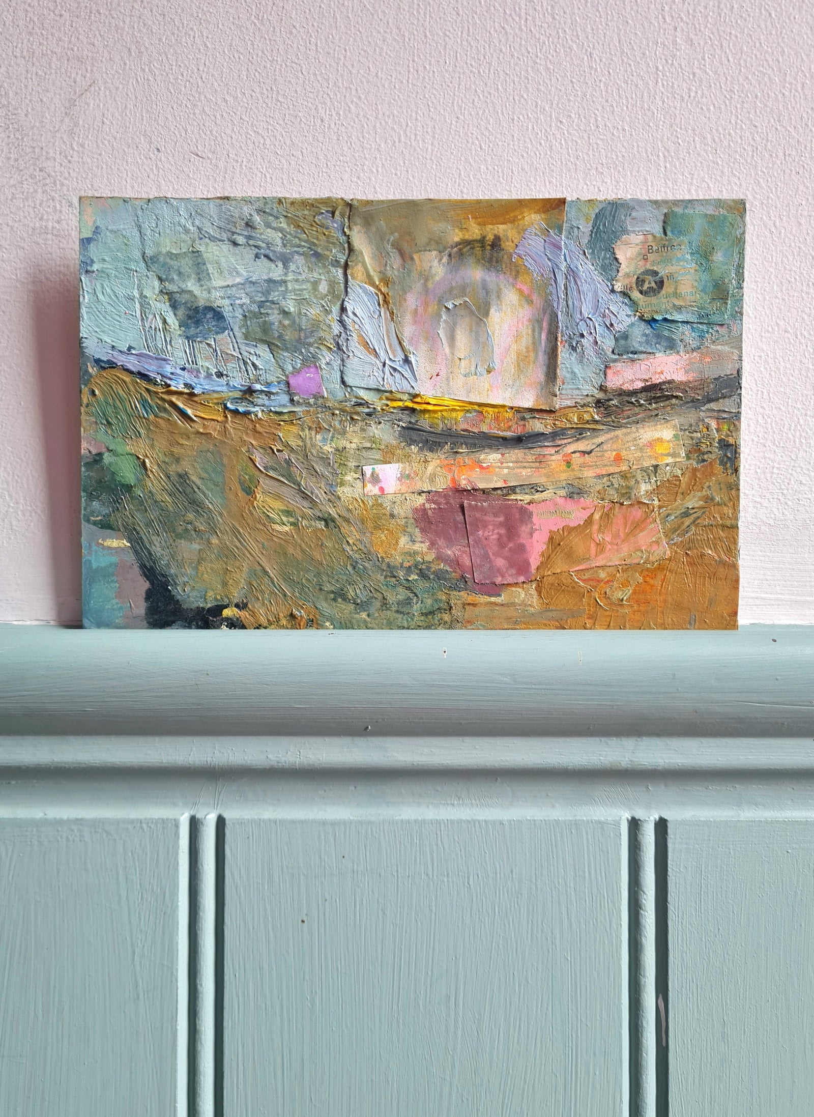 Abstract painting on a white wall with light blue painted woodwork