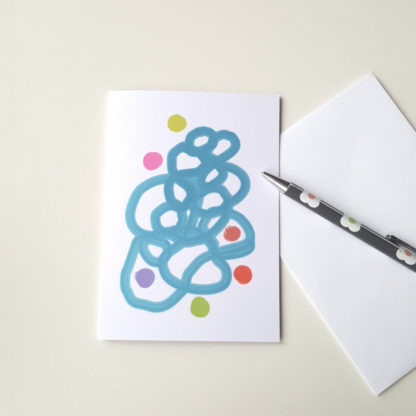 greeting card on white desk with white envelope and pencil.