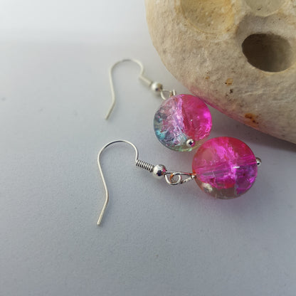 Pink glass bead drop earrings with a hint of sparkle lying on a white background