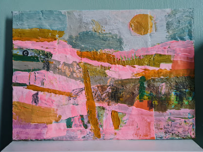 Abstract painting with pink, orange, and green colours on a white surface, and sage green background.
