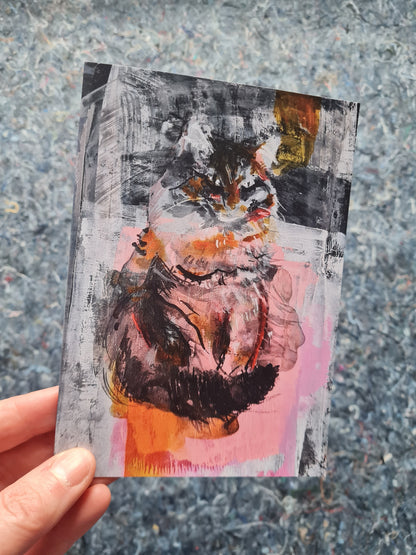 cat art greeting card held by a hand on a textured surface