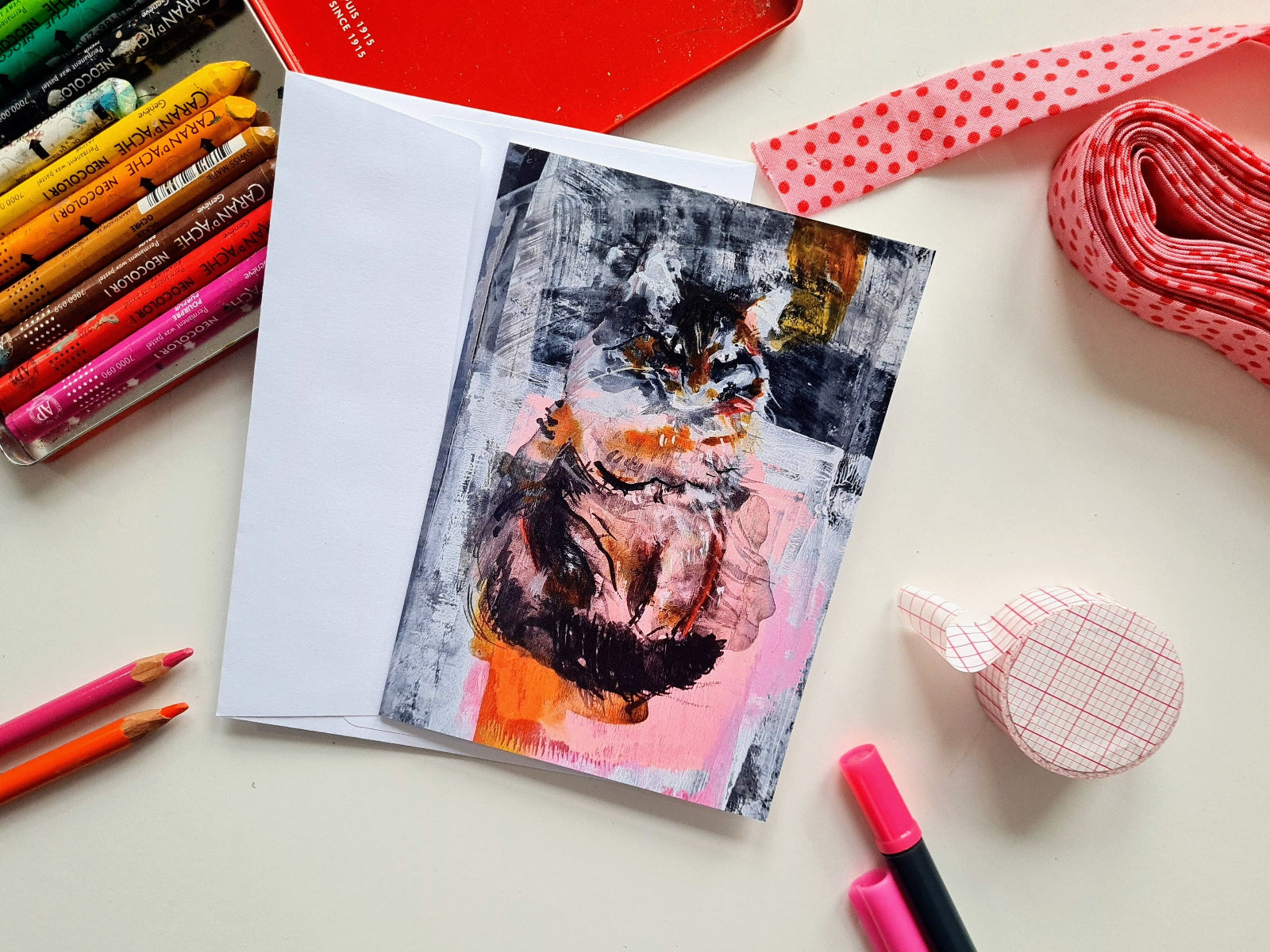 Artistic card with a cat design on a table with art supplies