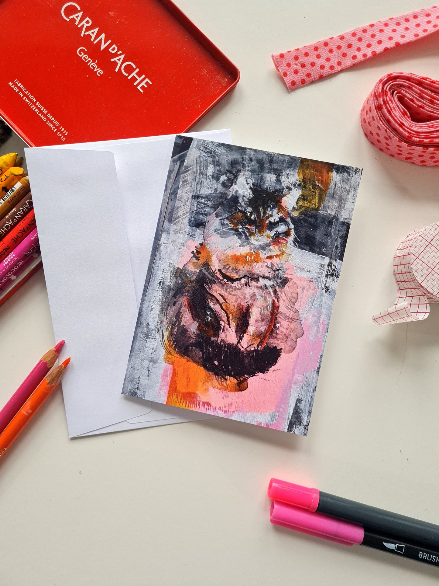 Artistic cat card with colourful design on a table with art supplies