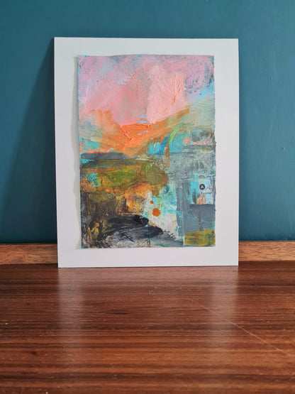 Abstract landscape mixed media painting on a wooden desk.