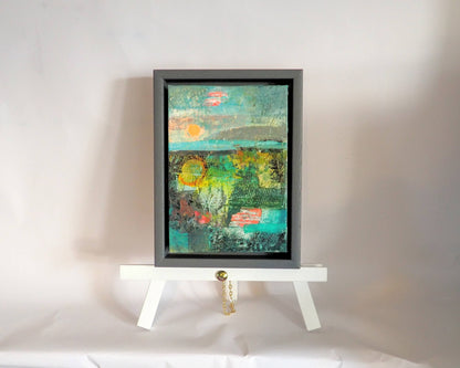 This small abstract landscape sits on a white display easel. The background is white.