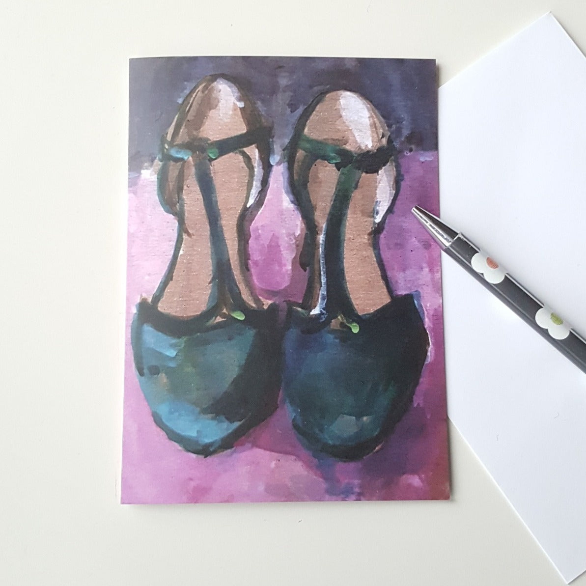 shoes greeting card on white desk with pen and evelope.