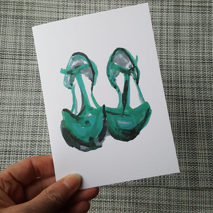 green shoes greeting card being held in front of the camera by a hand.