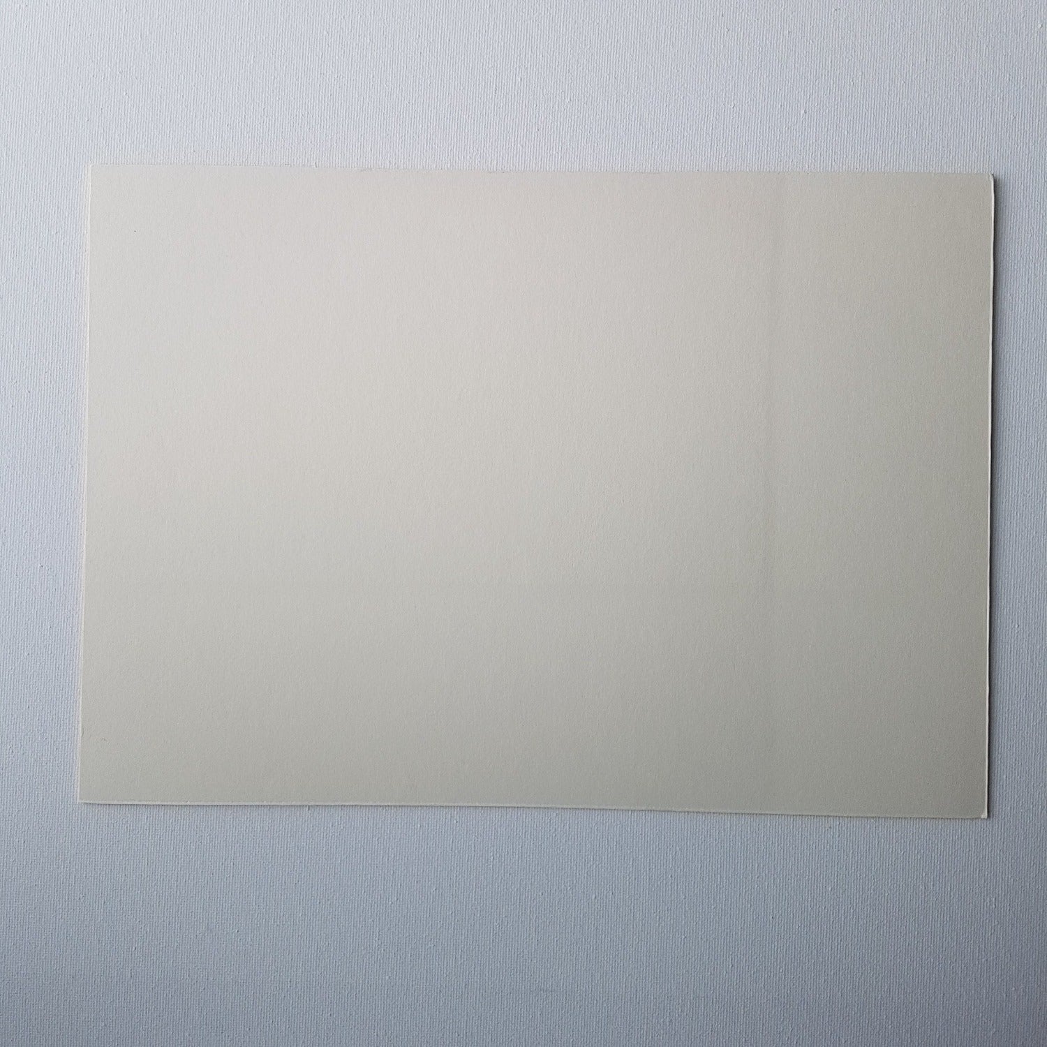 Back of cream coloured mounting board on a white background.