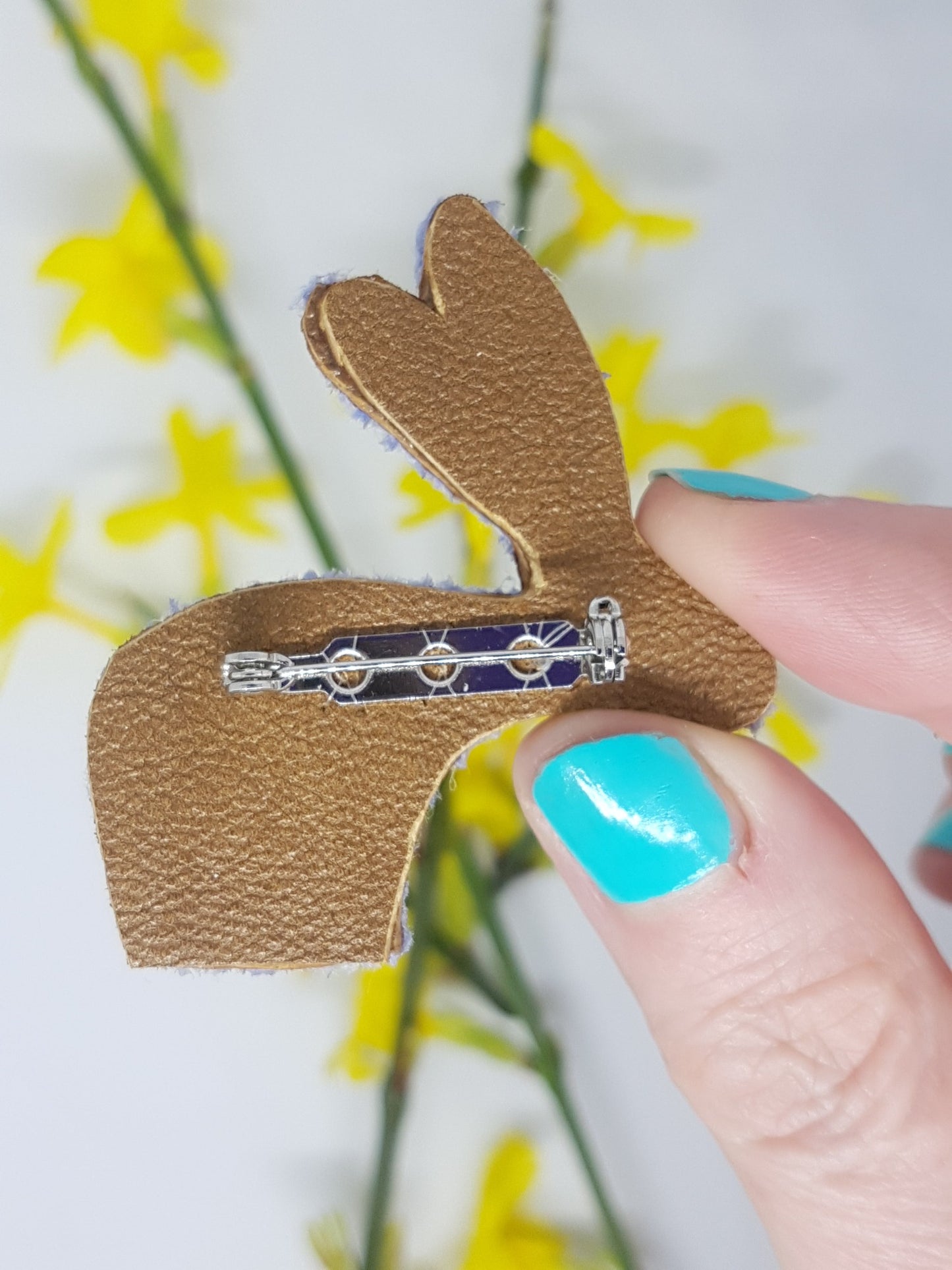 Back of rabbit brooch made of tan leather with silver coloured metal fastener