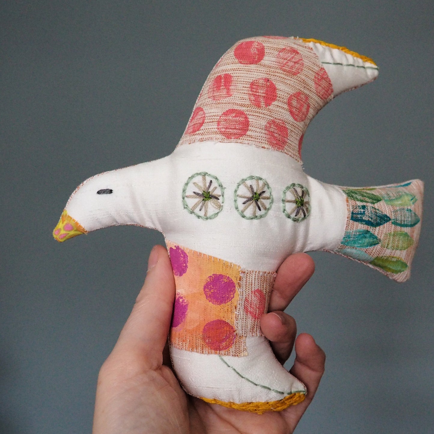 hand holding a handmade textile-art bird